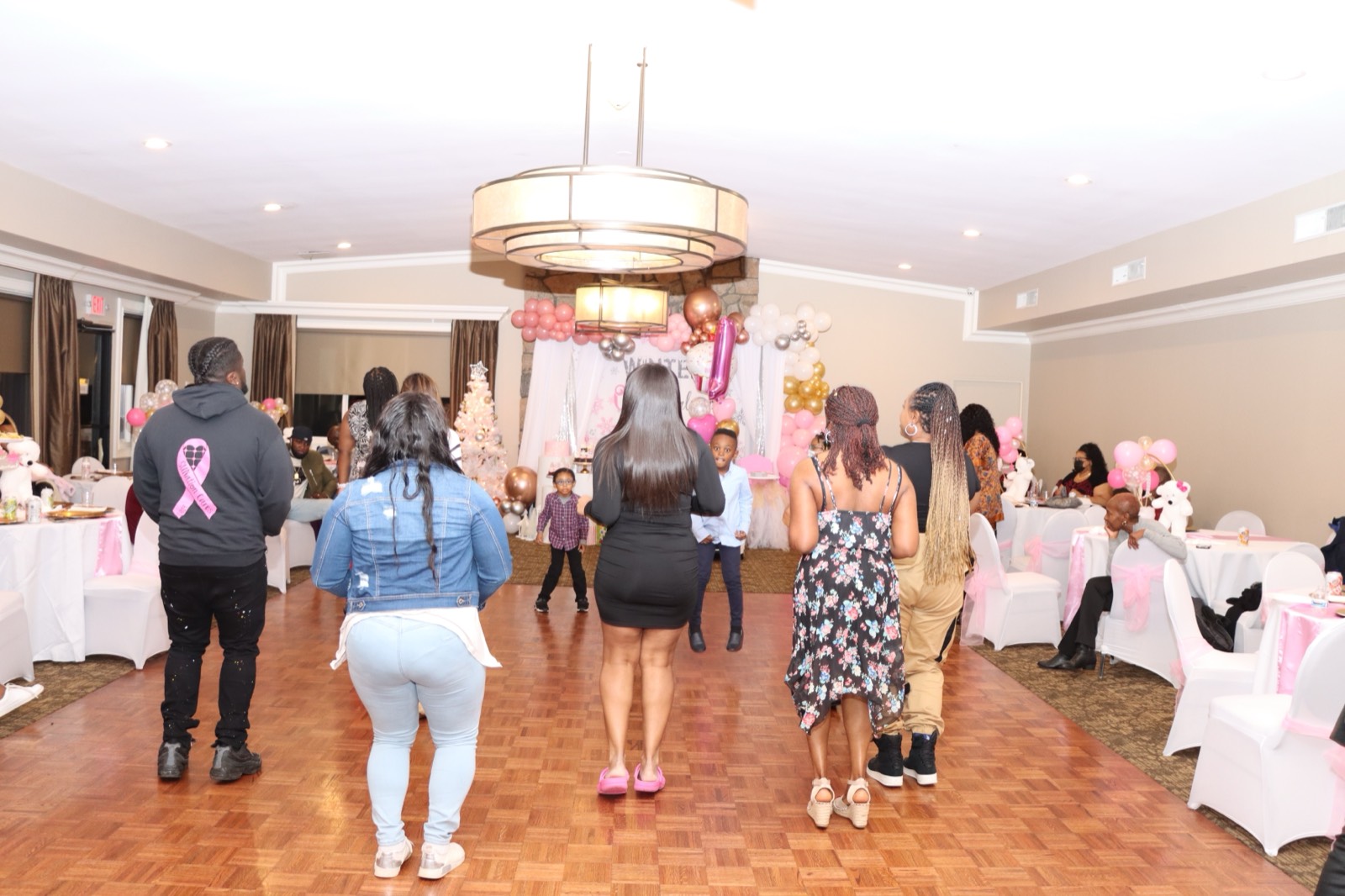 Guests and children gathering toward the 'Winter ONEderland' backdrop during the celebration.